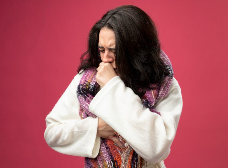 aching-young-ill-woman-wearing-robe-scarf-keeping-hand-chest-fist-mouth-coughing-with-closed-eyes-isolated-pink-wall