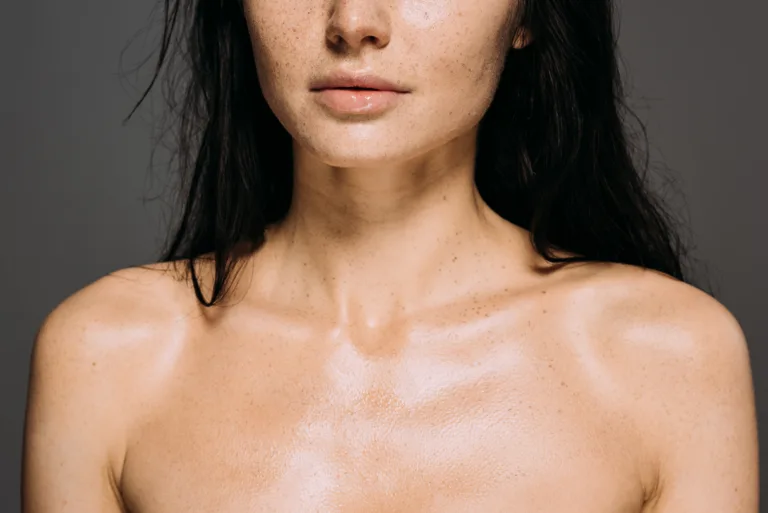 cropped view of naked girl with freckles on face isolated on grey