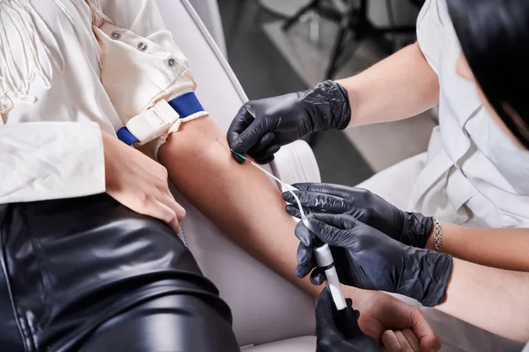 Process of taking blood sample in blood tube from a patient in a chair in beauty salon